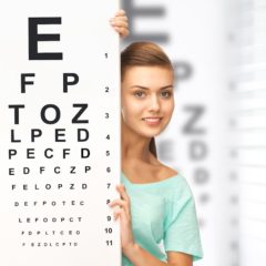 Girl behind a large eye chart