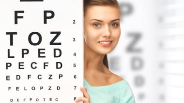 Girl behind a large eye chart