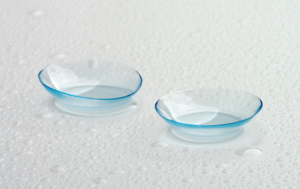 Two Contact Lenses with Water Droplets isolated on Grey Wet background