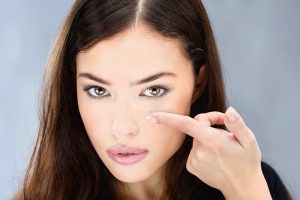 Woman inserting a contact lens into her eye